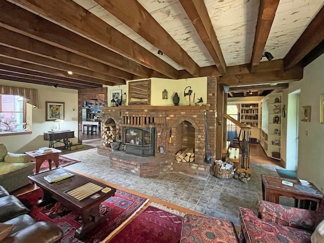 living room featuring beam ceiling and a wood stove