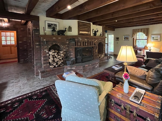 living room featuring a brick fireplace, beamed ceiling, and a wood stove