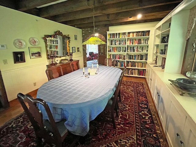 dining area with dark hardwood / wood-style floors and beam ceiling