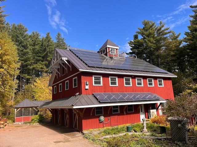 view of front of property featuring solar panels and a carport