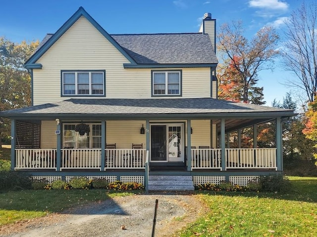 farmhouse-style home with a front yard and covered porch