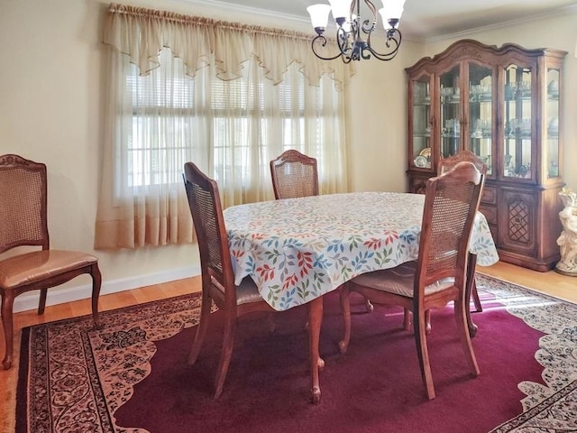 dining room with crown molding, hardwood / wood-style floors, and a chandelier