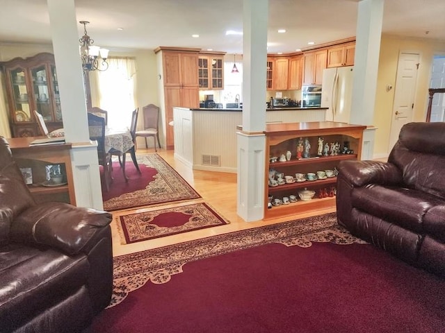 living room featuring sink, light hardwood / wood-style flooring, and a chandelier