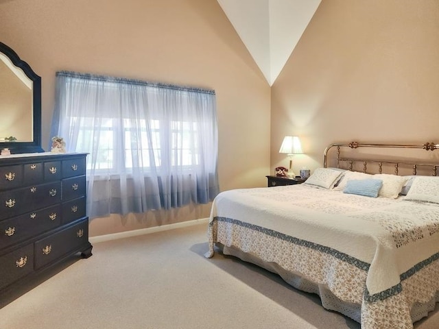 carpeted bedroom featuring high vaulted ceiling