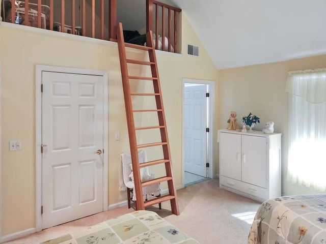 carpeted bedroom with high vaulted ceiling