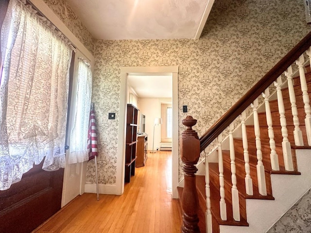 interior space with wallpapered walls, wood finished floors, and lofted ceiling