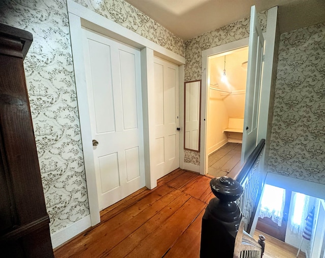 bathroom featuring baseboards, wallpapered walls, and a soaking tub