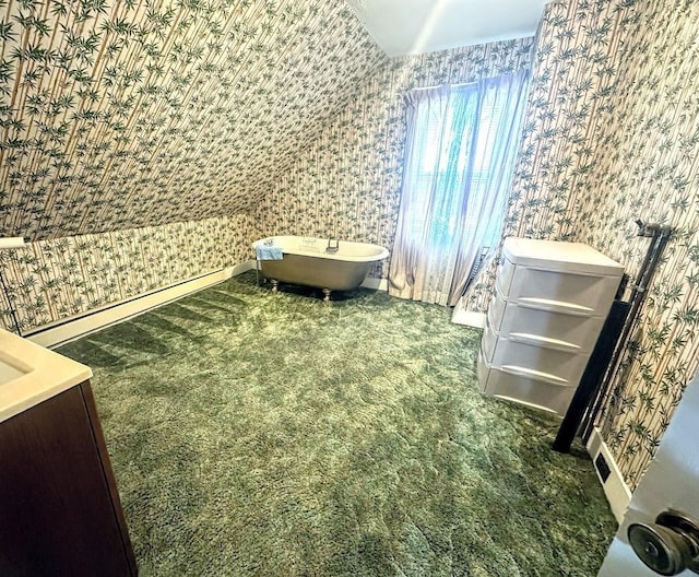 bedroom featuring baseboards, lofted ceiling, wood finished floors, and wallpapered walls
