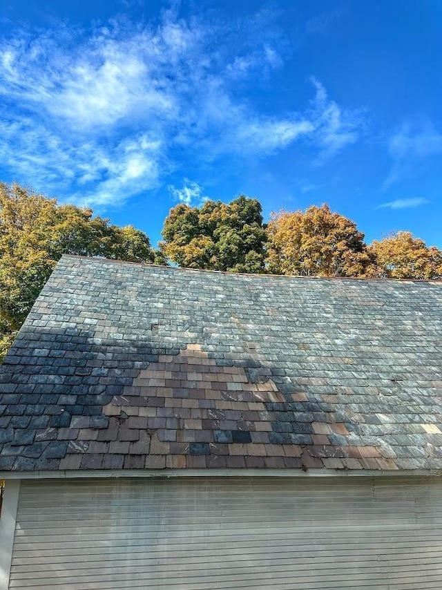 view of property exterior with a garage, a standing seam roof, a lawn, and a deck