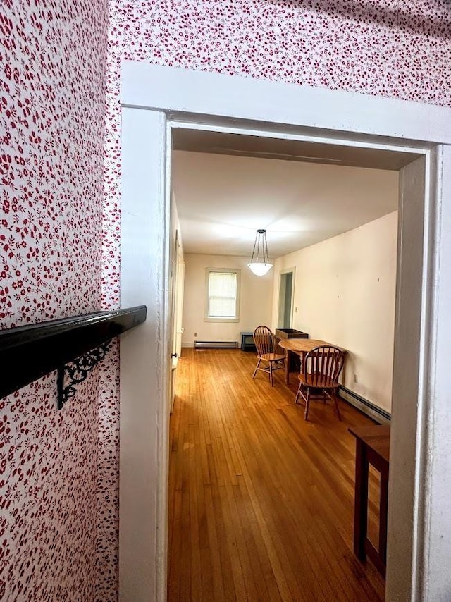 dining space with ornate columns, a baseboard heating unit, visible vents, and light wood-type flooring