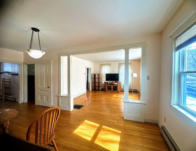 kitchen featuring brown cabinets, light wood finished floors, wallpapered walls, and white appliances