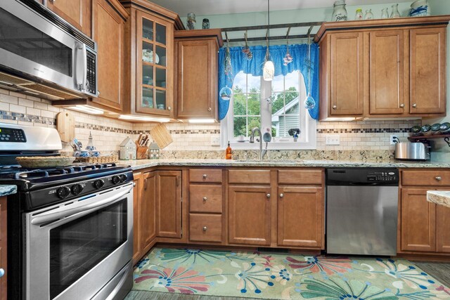 kitchen featuring pendant lighting, sink, stainless steel appliances, and tasteful backsplash