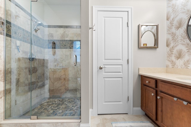 bathroom featuring a shower with door, tile patterned floors, and vanity