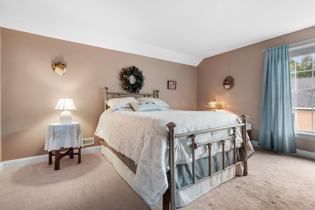 carpeted bedroom with lofted ceiling