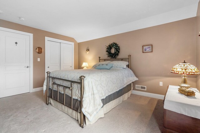 bedroom with carpet floors, a closet, and lofted ceiling