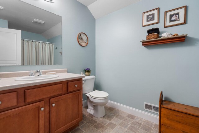 bathroom with vaulted ceiling, vanity, and toilet