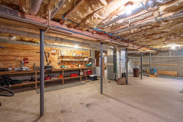 basement featuring a workshop area and heating unit