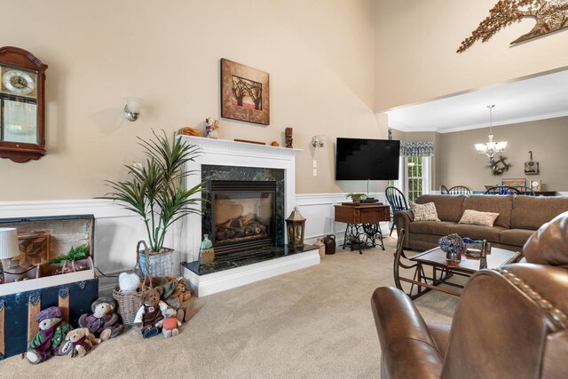 living room with light carpet, a fireplace, crown molding, and a chandelier