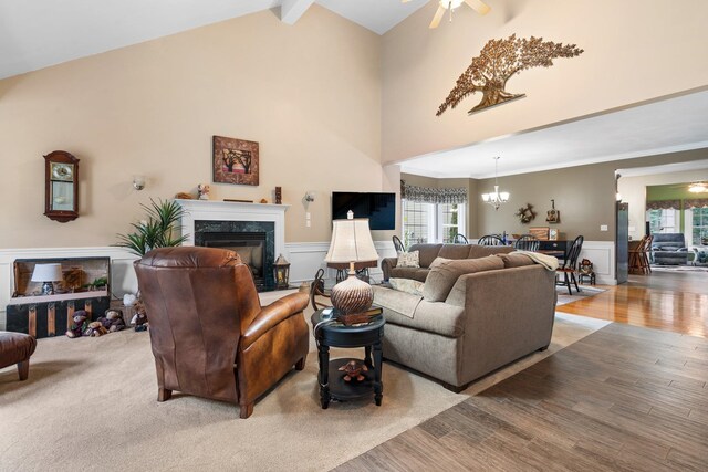 living room featuring ceiling fan, beam ceiling, plenty of natural light, and light hardwood / wood-style floors