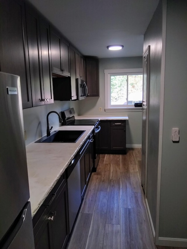 kitchen with sink, appliances with stainless steel finishes, and dark hardwood / wood-style flooring