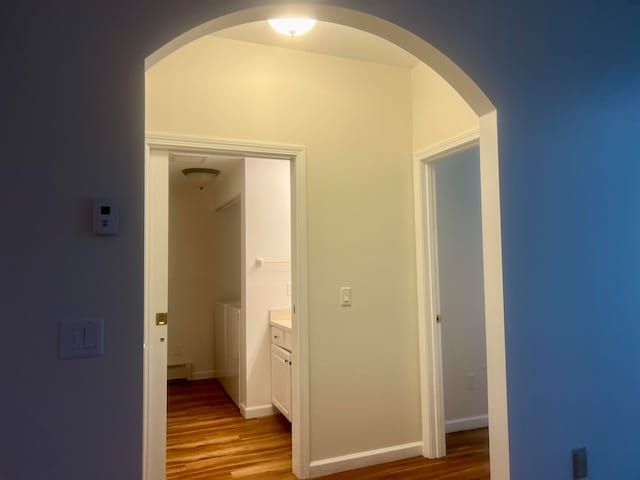 hall featuring wood-type flooring and a baseboard heating unit