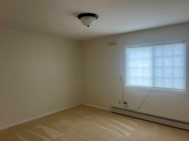 empty room with light colored carpet and baseboard heating