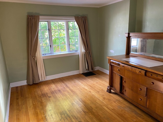 interior space featuring crown molding and light hardwood / wood-style flooring