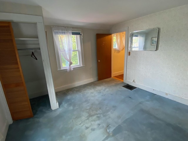 unfurnished bedroom featuring dark carpet and a closet