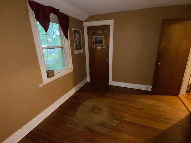 hallway with lofted ceiling and dark wood-type flooring