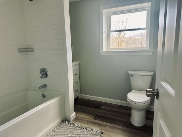 full bathroom with toilet, shower / bath combination, wood finished floors, and baseboards