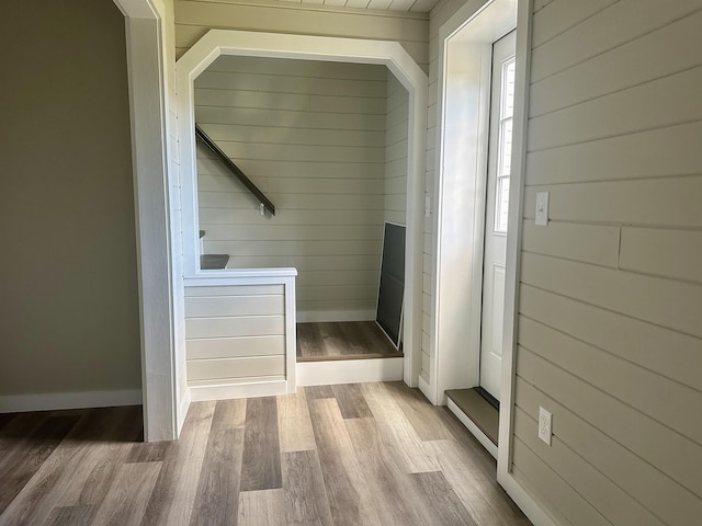 mudroom with wooden walls and wood finished floors