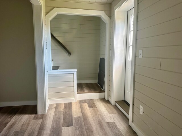 mudroom featuring wooden walls, wood finished floors, and baseboards