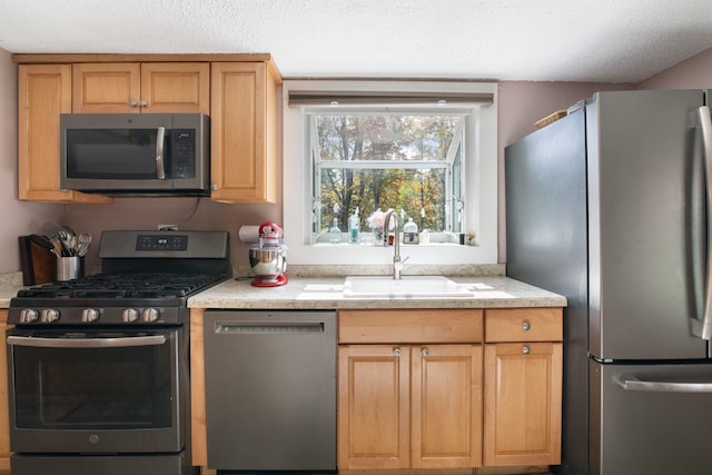 kitchen featuring sink, stainless steel appliances, and a textured ceiling