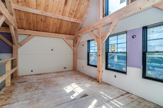 interior space featuring beam ceiling, high vaulted ceiling, and light hardwood / wood-style flooring