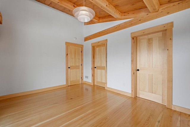 unfurnished living room with high vaulted ceiling, beam ceiling, and hardwood / wood-style flooring