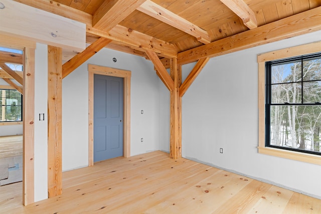 empty room featuring beam ceiling, light hardwood / wood-style flooring, and wood ceiling