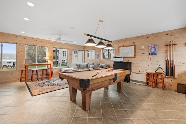 recreation room with tile patterned floors, ceiling fan, wood walls, and pool table