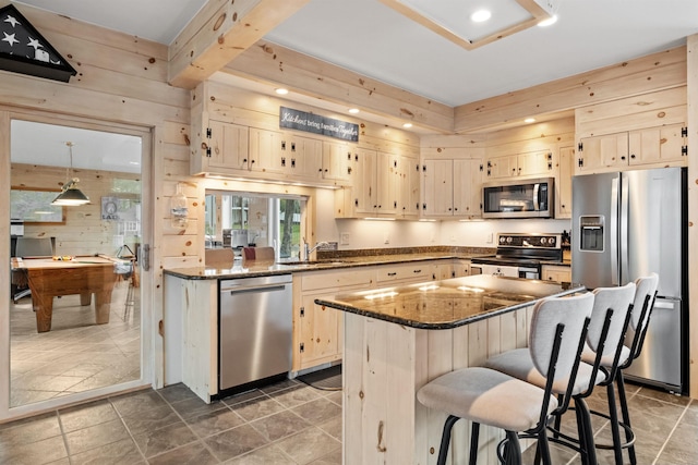 kitchen featuring sink, stainless steel appliances, billiards, dark stone countertops, and a kitchen island