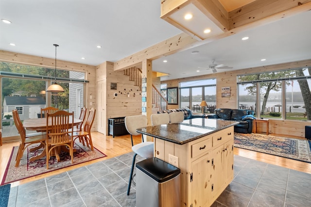 kitchen featuring a breakfast bar area, ceiling fan, a healthy amount of sunlight, and dark hardwood / wood-style floors