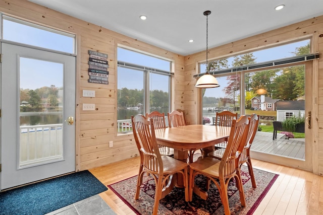 dining space featuring plenty of natural light, a water view, and light wood-type flooring