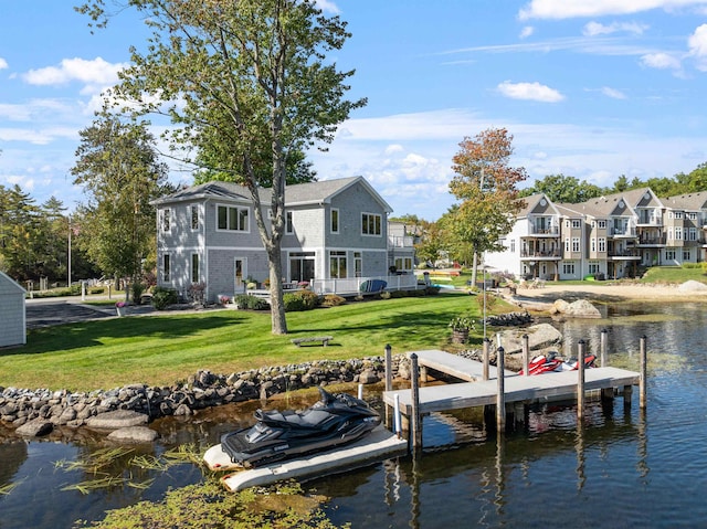 view of dock with a water view and a lawn