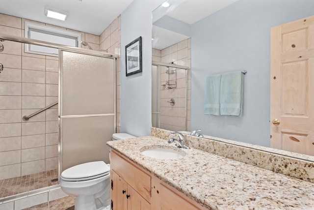 bathroom featuring vanity, toilet, and an enclosed shower