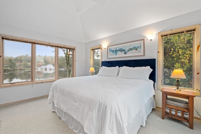 carpeted bedroom with ceiling fan, a water view, and vaulted ceiling