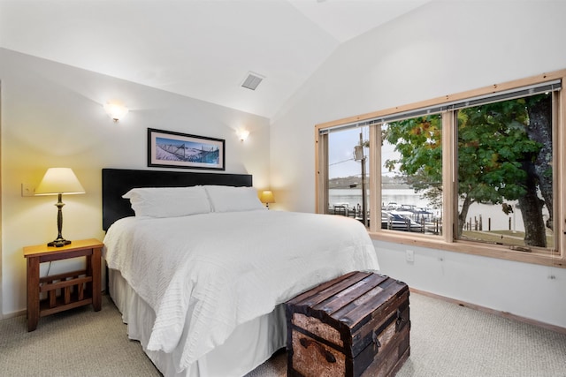 carpeted bedroom with a water view and vaulted ceiling