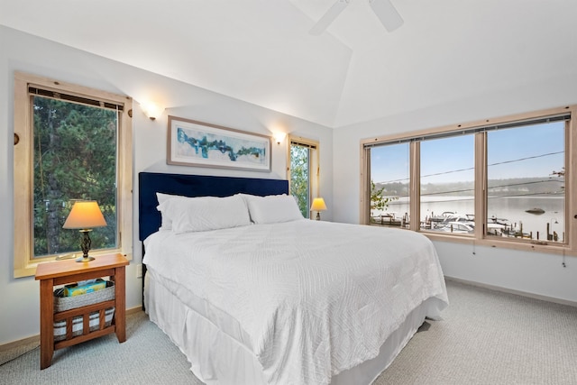 bedroom featuring ceiling fan, a water view, light colored carpet, and lofted ceiling