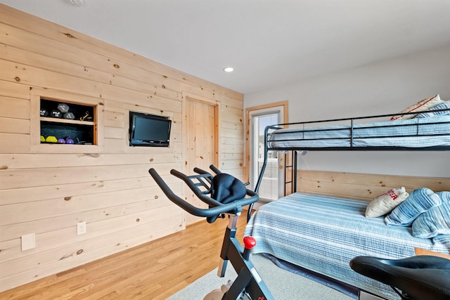 bedroom featuring hardwood / wood-style floors and wood walls