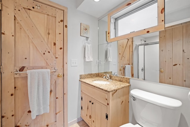 bathroom with an enclosed shower, vanity, and toilet