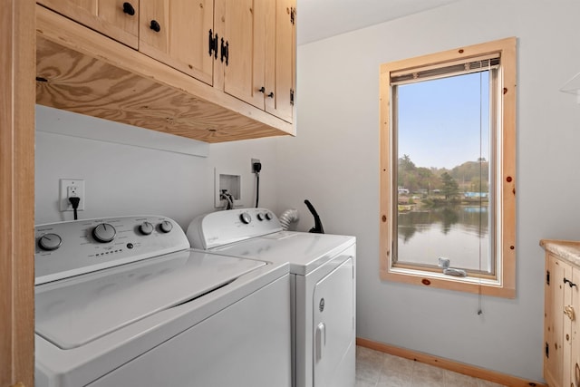 clothes washing area with washer and clothes dryer and cabinets