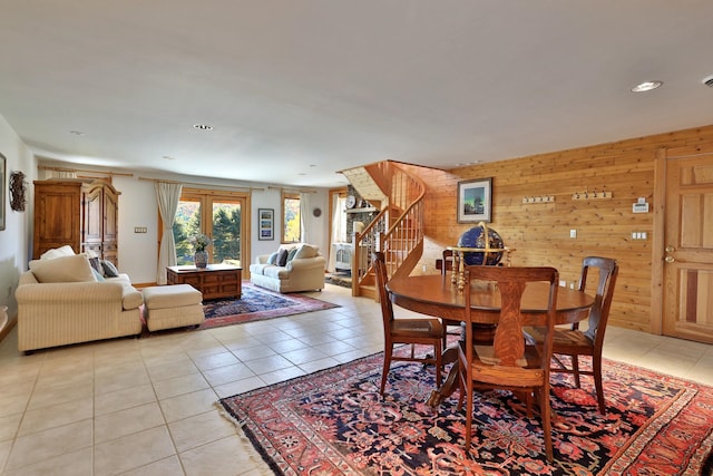 tiled dining room featuring wood walls