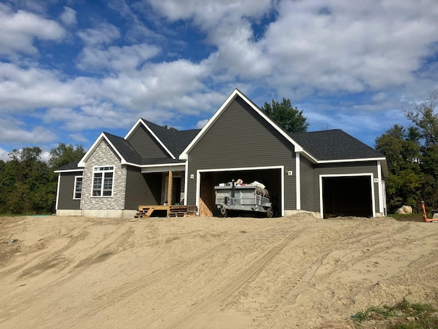 view of front of property with an attached garage, stone siding, a shingled roof, and dirt driveway